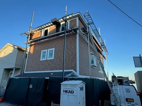 Shingle siding going on from the staging
