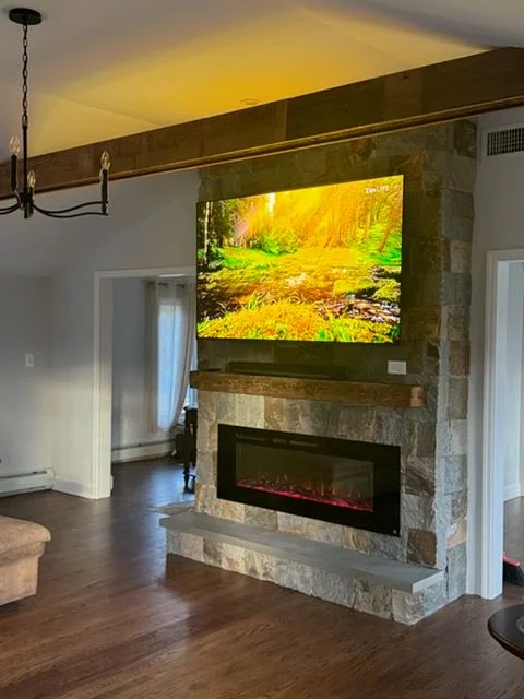 Stone surround, wood mantel and a linear electric fireplace