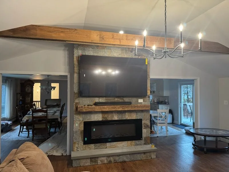 Stone fireplace wall with a reclaimed wood mantel