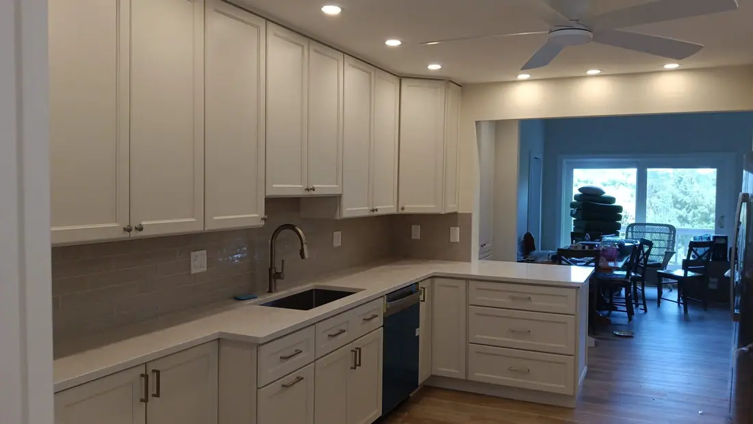 White shaker kitchen opening into a bright dining area