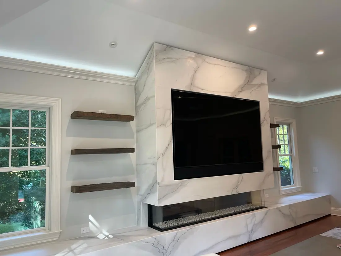 Slab media wall with floating wood shelves and a linear fireplace