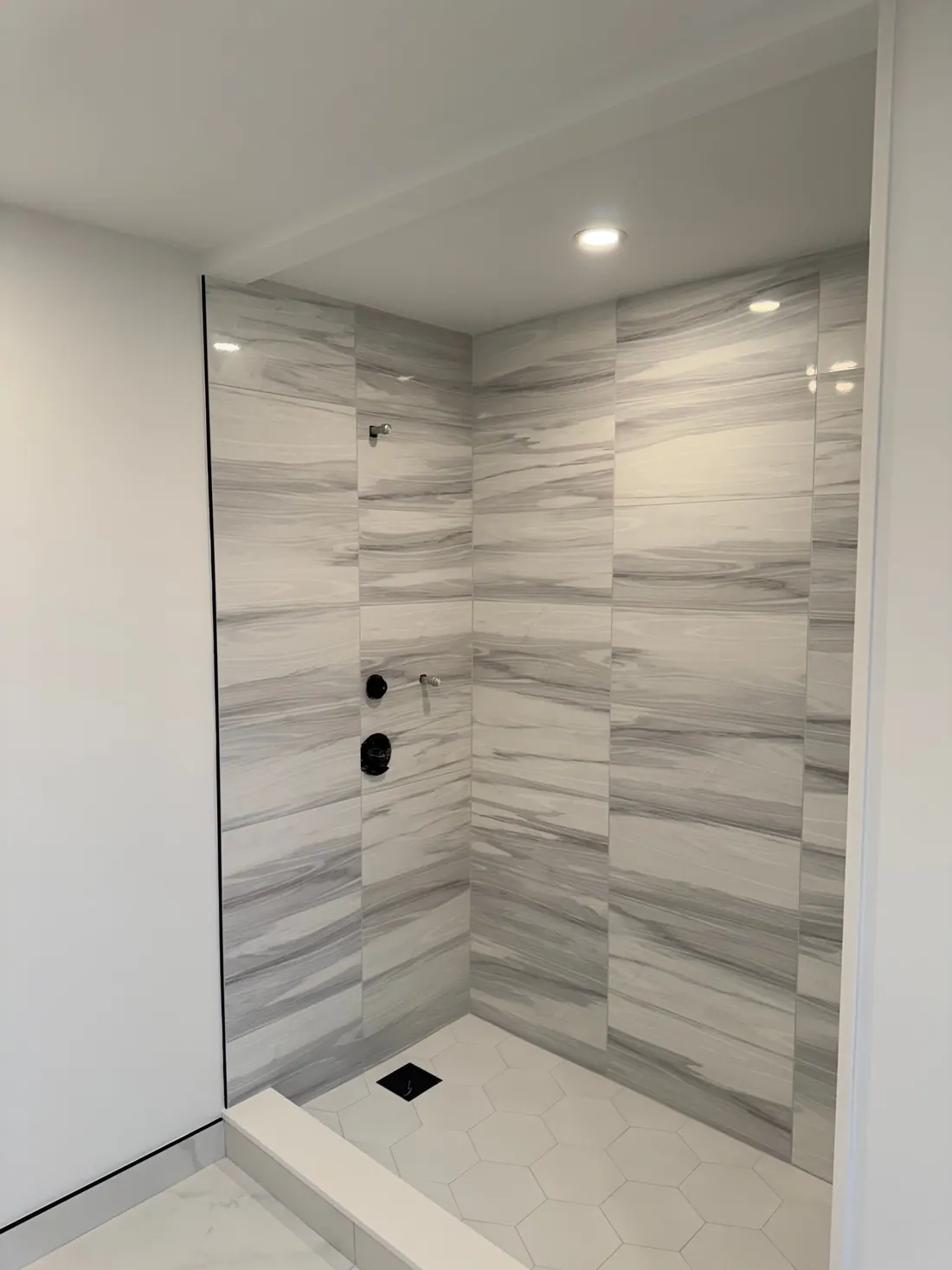 Walk-in shower in veined porcelain tile