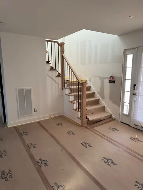 New oak stair at the front door, floors still covered